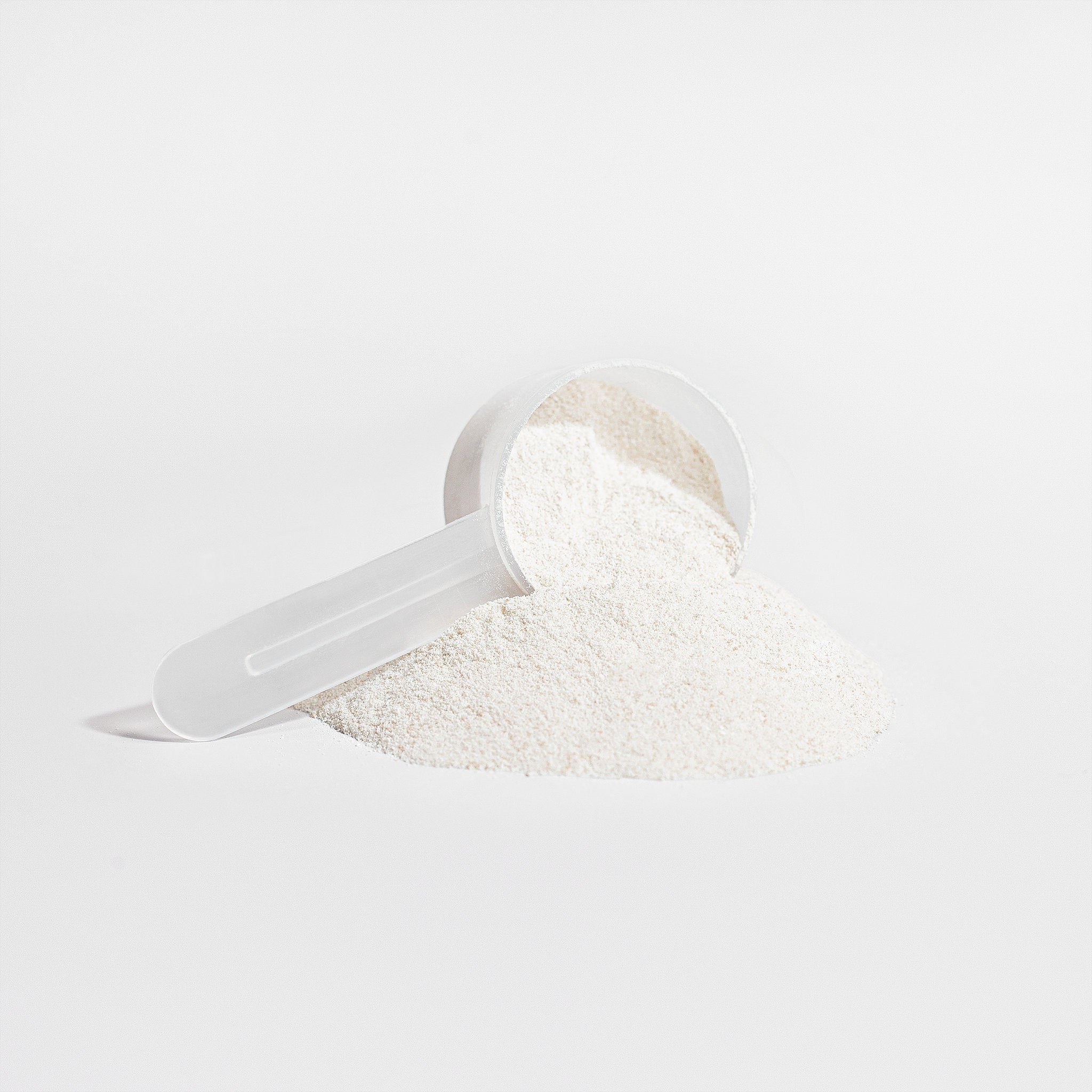 Promised vanilla grass-fed collagen creamer powder with a plastic measuring scoop on a white background